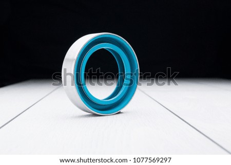 Ball bearing wheel on wooden surface with a dark background