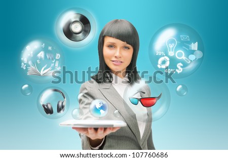 Pretty business woman holding tablet computer and different objects are flying from touch screen