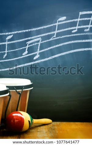 drums on wooden table with music notes on black background