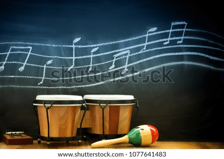 drums on wooden table with music notes on black background