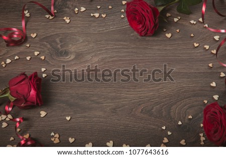 Festive flower red roses composition with ribbon and heart on wooden background. Overhead top view, flat lay. Copy space. Birthday, Mother's, Valentines, Women's, Wedding Day concept.