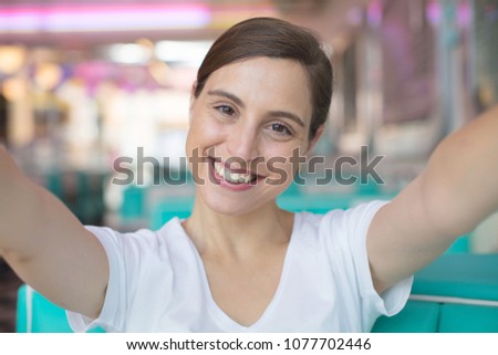 young pretty woman taking a selfie in an american dinner restaurant