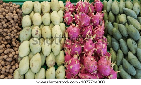 Variety of tropical fruits (Dragon fruits, mango, longan) on the market shelf 