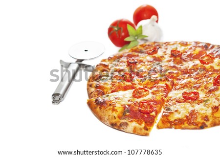 Close-up of stone backed pizza margarita with sun dried tomatoes and pesto with disk pizza knife.  isolated on white background. Selective focus