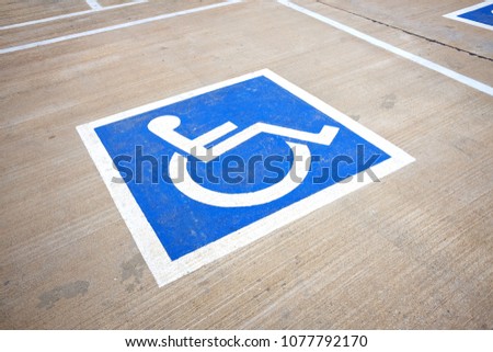 Handicapped sign painted on the floor to reserve parking lot for disabled.
