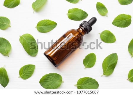Essential oil with fresh mint leaves.