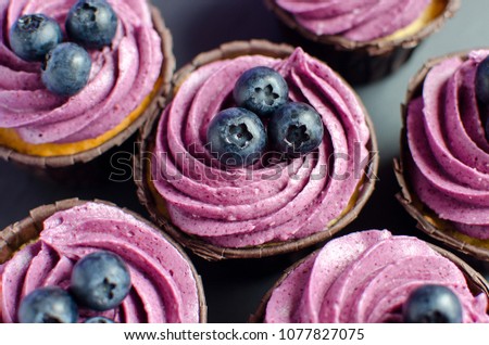 Cupcakes with blueberry creme on black plate