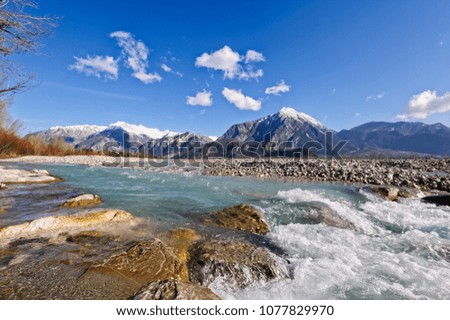 Mountain landscape,with river rocks and waterfall against blue sky.