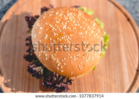 top view of the beef burger on wooden plate, on the street, outdoor, fast food