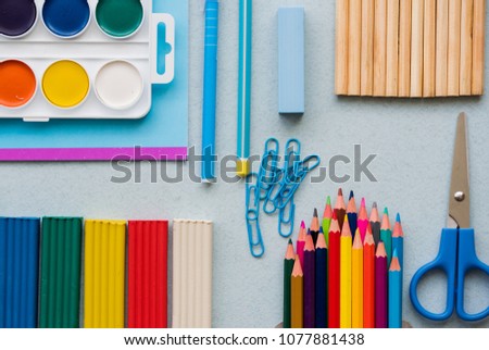 good preparation for school subjects. School accessories of color plasticine, multi-colored pencils, paper clip scissors pen and watercolor paints. top view