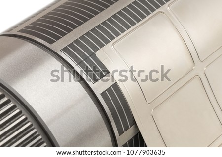 Magnetic cylinder with attached flexible die for die cutting on rotary printing press. Magnetic roll with cutting die for  die cutting on in-line or flexographic press machine. Close-up shot. Royalty-Free Stock Photo #1077903635