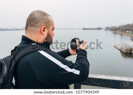 Traveler photographer on bridge is taking picture.