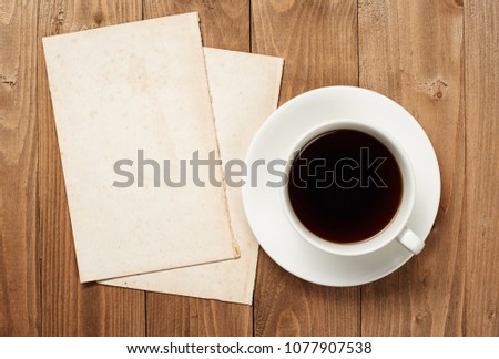cup of coffee on wooden boards, blank paper sheet with place for text - holiday and greeting concept
