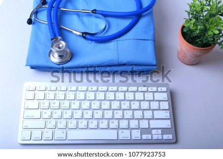 Doctor coat with medical stethoscope and keyboard on the desk