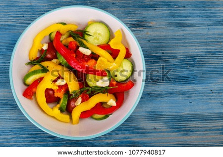 Summer vegetarian fresh vegetable salad on blue wooden background. Studio Photo