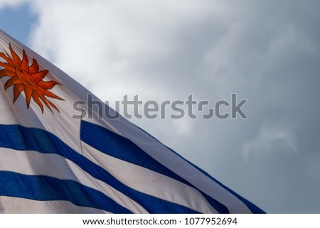 national flag of Uruguay blowing in the wind with blue sky in background