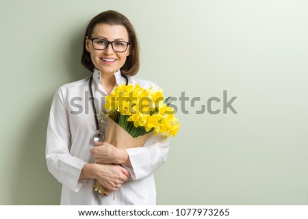 Smiling woman doctor with bouquet Royalty-Free Stock Photo #1077973265