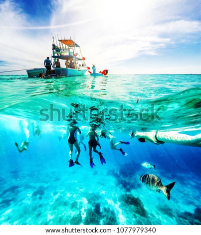 Group of friends on a Carribean Sea adventure with party boat, snorkeling and scuba diving Royalty-Free Stock Photo #1077979340