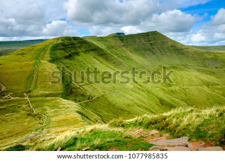Walking the Scenic Brecon Beacons National Park in south Wales on a sunny summers day. Descending path from Fan Y Big.  Royalty-Free Stock Photo #1077985835