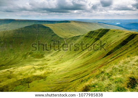 Walking the Scenic Brecon Beacons National Park in south Wales with a cloudy sky.  Royalty-Free Stock Photo #1077985838