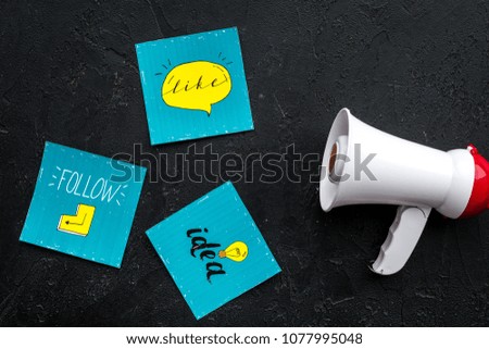 Social media announcements concept. Megaphone near social media icons on black background top view
