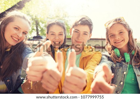 friendship, gesture and people concept - happy teenage friends or high school students showing thumbs up