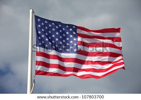 American flag waving against a cloudy sky