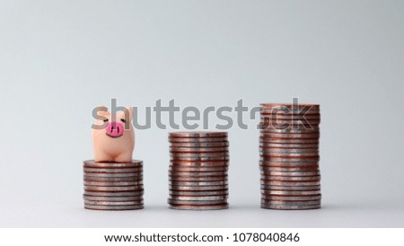 A pile of coins and a pink piggy bank. The concept of financing through savings.
