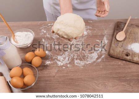 Female hands making dough for pizza. Woman kneading dough on table, closeup. Close up of a baker kneading and shaping bread dough into a ball.