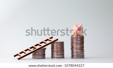 Small piggy bank and ladder on top of the pile of coins. Cost creation concept.