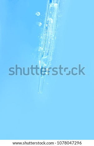 serum or liquid  particle from laboratory glass pipette
with blue water background