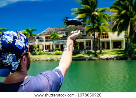 Man Launching a Personal Drone Hovering Over Water