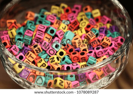 Colorful letter alphabet beads square blocks in glass.