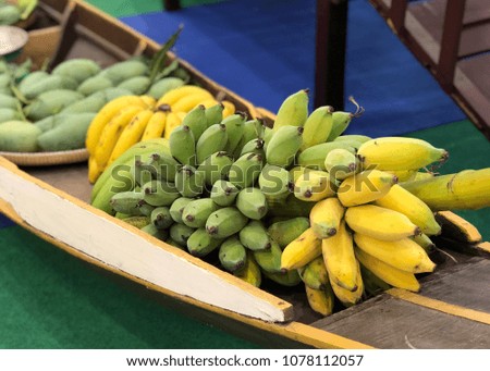 Banana and fruits in wooden boat closeup blur background