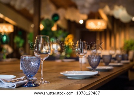 An empty glass of wine stands on a wooden table. Beautifully sealed table. Royalty-Free Stock Photo #1078129487