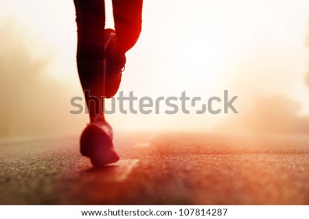 Runner athlete feet running on road. woman fitness silhouette sunrise jog workout wellness concept. Royalty-Free Stock Photo #107814287