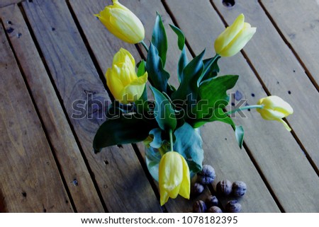 Spilled walnuts and bouquet of yellow tulips on the old background,on the roof.