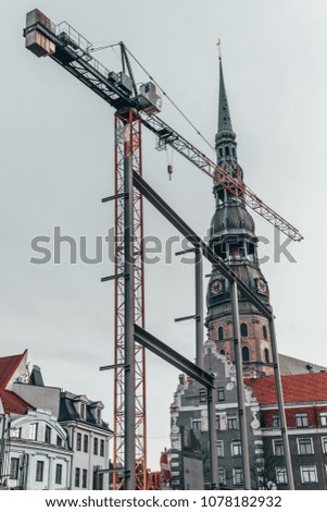 View on building crane next to the old church in Riga, Latvia, construction area