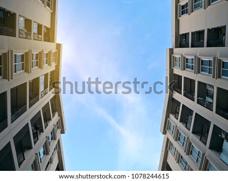 Low angle view of residential building condominium or apartment with blue sky and cloud background.