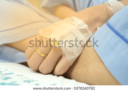 Focus on the hand of a patient in hospital ward, Patient's saline needle