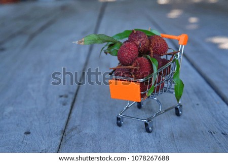 Lychee in a small cart,on wooden background.