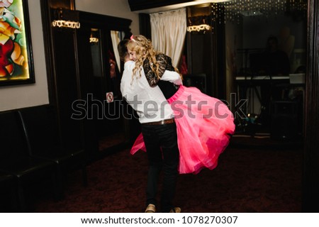 Young man and woman dance in a restaurant. Prince and Princess. Thematic holiday. The guy and girl hug.
