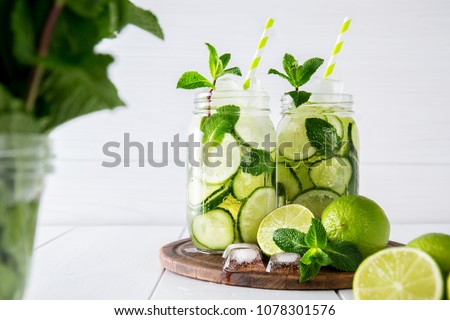 Fruit and herb infused water with cucumber, lime and mint on white background. The concept of detox and weight loss.
