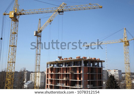 Working crane on the construction of the house. Construction site with cranes on sky background. 