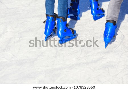 People skating with blue skates on the ice area 