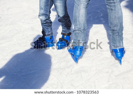 People skating with blue skates on the ice area 