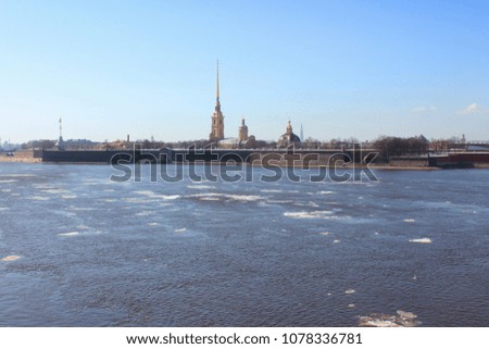 Peter and Paul Fortress in Saint Petersburg City, Russia. Scenic Outdoors View of Popular Tourist Landmark with Neva River Water with melting Ice and Sky Background on Sunny Spring Day Landscape. 