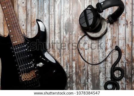guitar on a wooden background with headphones