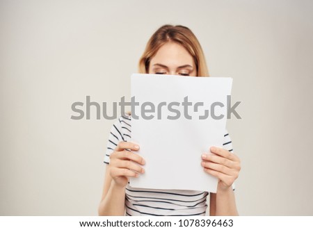 woman with a white sheet of paper in front of her eyes                             