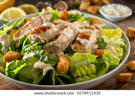 A delicious chicken caesar salad with parmesan cheese, dressing and croutons. Royalty-Free Stock Photo #1078415420